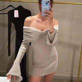 Person wearing a beige off-shoulder dress taking a mirror selfie.
